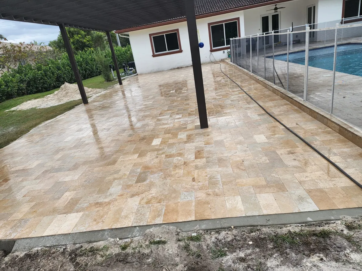 Warm stone terrace beside a glass pool fence
