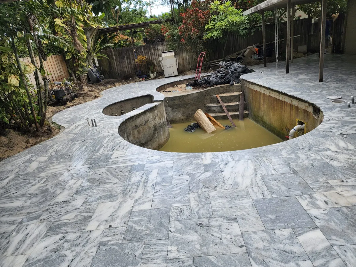 Gray veined stone laid around a pool under renovation
