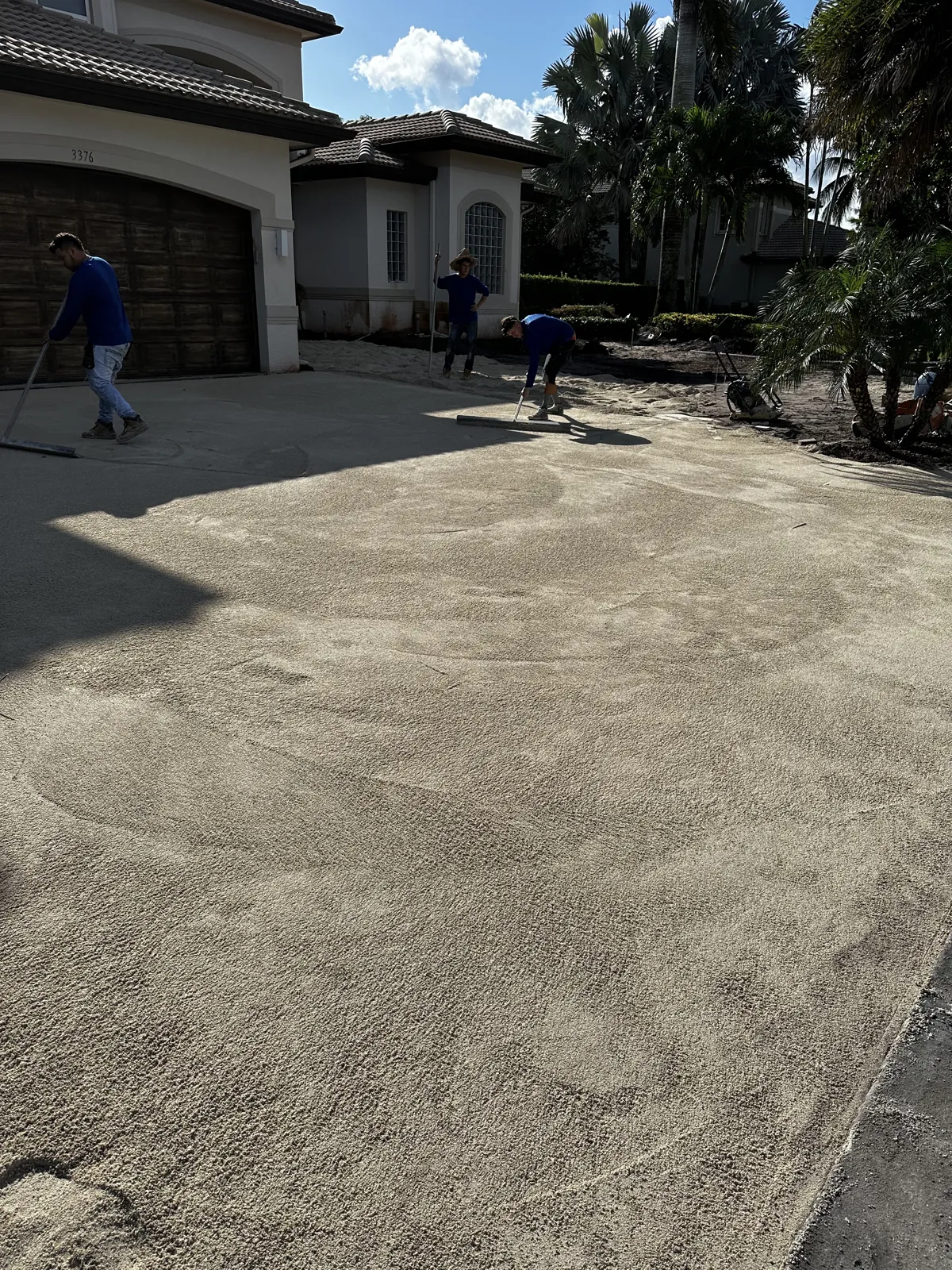 Leveled sand base being screeded for new driveway paving