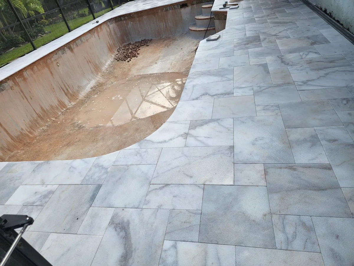 Light veined marble laid along the edge of a drained pool